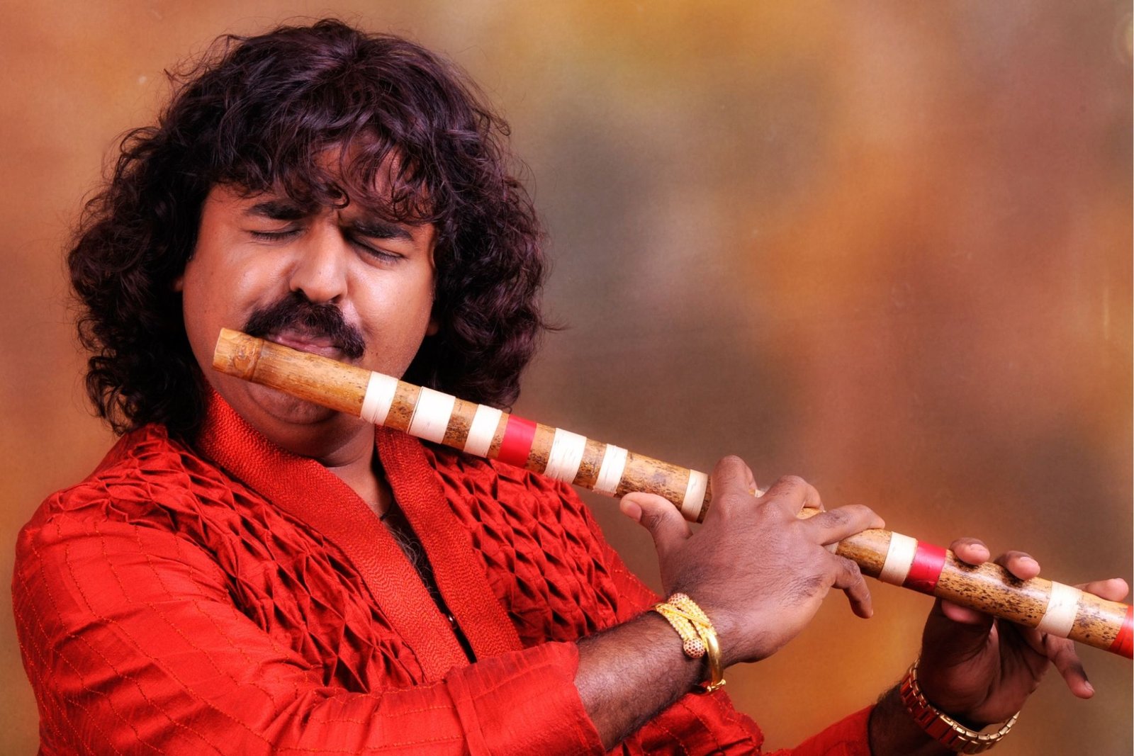 Close view of a bansuri player with lips at the blowing hole and fingers on the flute